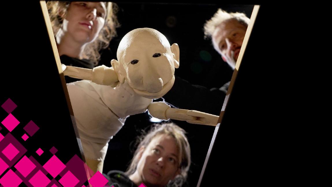 Une marionnette est manipulée par 3 marionettistes.