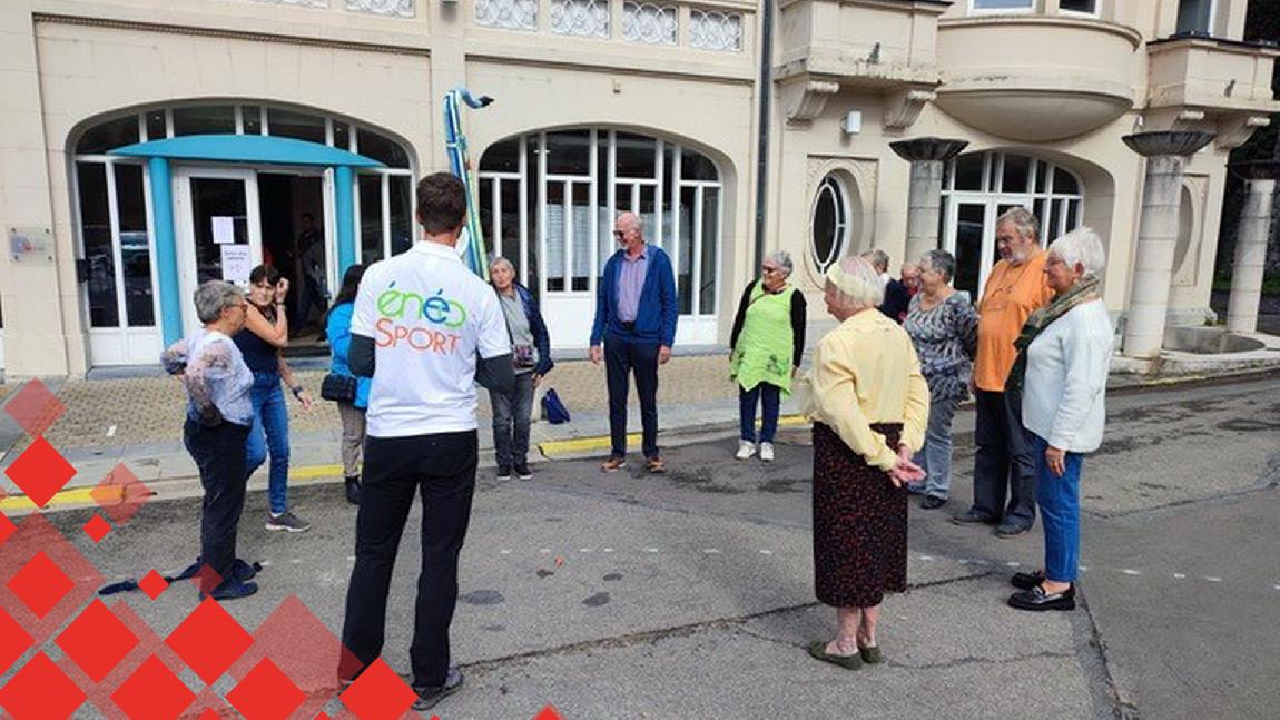 Un groupe de personnes âgées discutent en rond dehors.