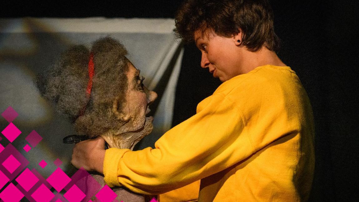 Une jeune comédienne parle à une marionnette qui représente une vieille femme.